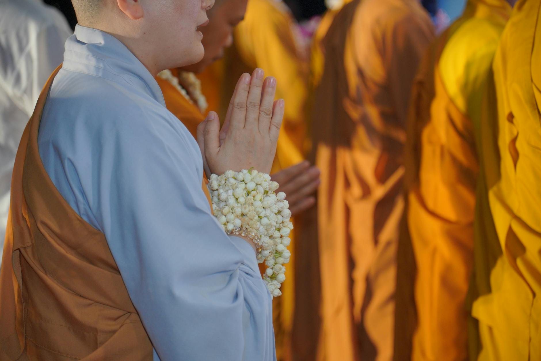 พุทธศาสนิกชนไทยแต่งขาวถวายเทียนพระสงฆ์ที่พิธีวัดระหว่างเข้าพรรษา