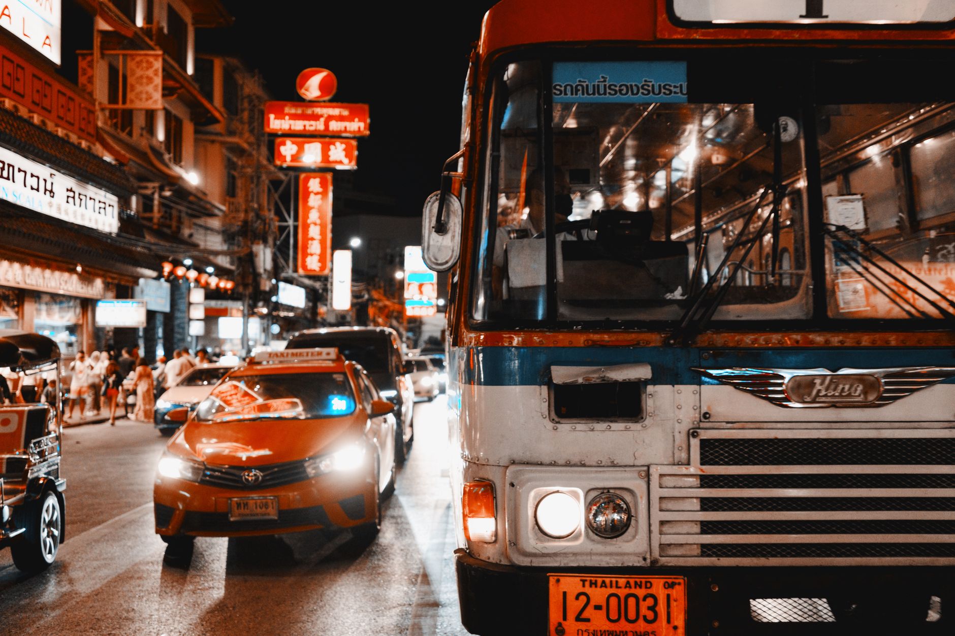 Colorful tuk-tuk moving through a Bangkok street